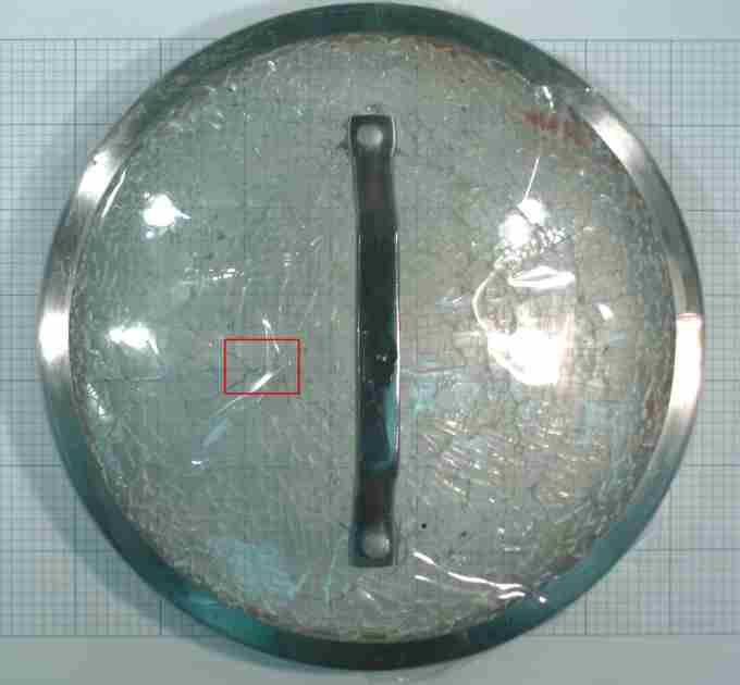 Fractured glass lid - fracture origin outlined